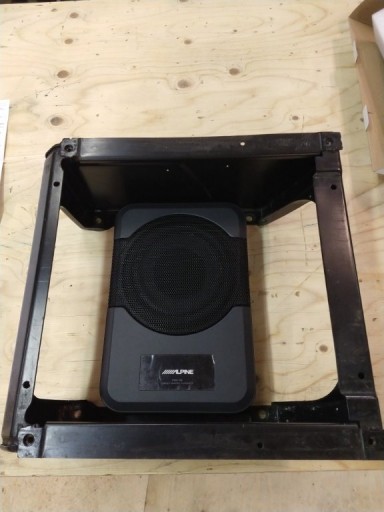 De Alpine subwoofer, past met gemak in het standaard stoelframe, alleen je moet even een ophangsysteem maken, zodat hij mooi vrij van de vloer hangt en er niet door de achterpassagiers met de voeten bovenop wordt gestaan.