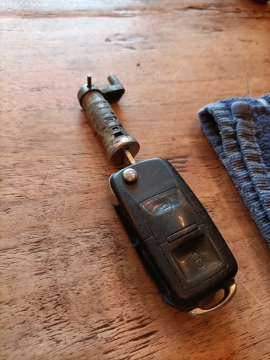 De cilinder haal je uit de deurgrepen, door met de sleutel de cilinder wat te draaien, zodat je met de hamer en kleine doorslag, of inbussleutel, het borgpennetje er uit te tikken. Als deze voldoende naar buiten komt, kun je hem met een tang pakken, en hem er voorzichtig uit te trekken en draaien.<br />Als het pennetje er uit is, pak je de achterkant er af, en trek je met de sleutel zo de cilinder er uit.<br />Je hoeft niet bang te zijn dat er allerlei onderdelen wegschieten, alles blijft bij elkaar zitten.